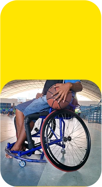 Atleta em cadeira de rodas segurando uma bola de basquete